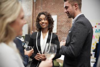 Business Team Socializing At After Works Drinks In Modern Office