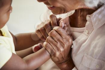 Close Up Of Grandmother Holding Hands With Baby Granddaughter Playing Game Together