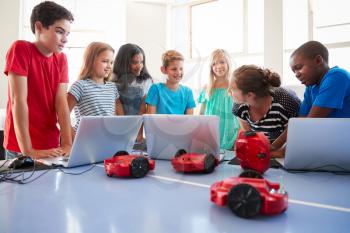 Group Of Students In After School Computer Coding Class Learning To Program Robot Vehicle