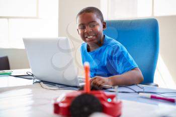 Male Student In After School Computer Coding Class Learning To Program Robot Vehicle