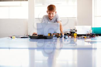 Male Student Building And Programing Robot Vehicle In School Computer Coding Class