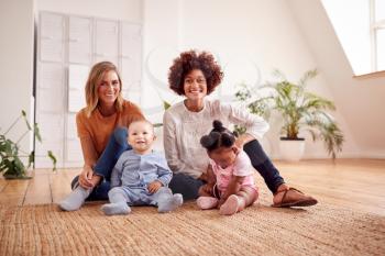 Portrait Of Two Mothers Meeting For Play Date With Babies At Home In Loft Apartment