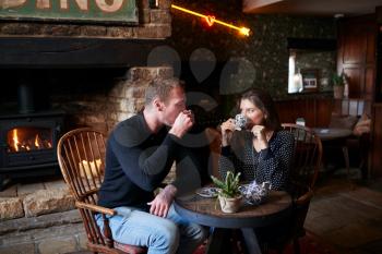 Couple Sitting At Table Drinking Tea In Traditional English Holiday Hotel