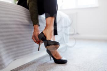 Close Up Of Businesswoman At Home Sitting On Bed Putting On Shoes Before Leaving For Work