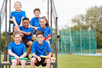 Portrait Of Childrens Athletics Team Preparing For Relay Race On Sports Day