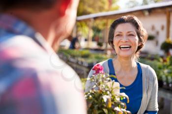 Mature Couple Outdoors Choosing Plants To Buy At Garden Center