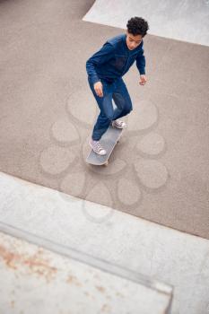 Young Woman Riding On Skateboard In Urban Skate Park