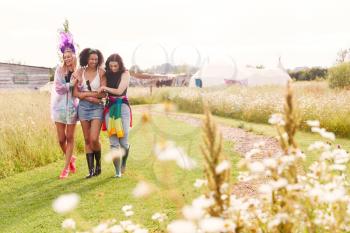 Female Friends Walking Back To Tent After Outdoor Music Festival