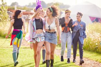 Female Friends Walking Back To Tent After Outdoor Music Festival