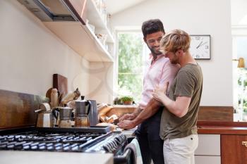Male Gay Couple At Home In Kitchen Making Breakfast Together
