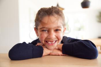 Portrait Of  Girl Wearing School Uniform Leaning On Kitchen Counter