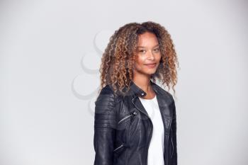 Waist Up Studio Shot Of Happy Young Woman Wearing Leather Jacket Smiling At Camera