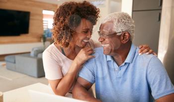 Senior African American Couple Using Laptop To Check Finances At Home