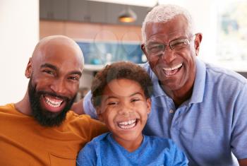 Portrait Of Multi-Generation Male African American Family Sitting On Sofa At Home