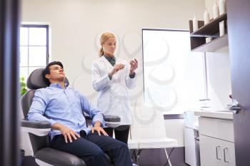 Man Sitting In Chair Being Give Botox Injection By Female Doctor