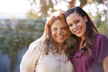 Portrait Of Senior Hispanic Mother With Adult Daughter In Garden At Home