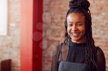 Portrait Of Smiling Female Coffee Shop Owner Wearing Apron
