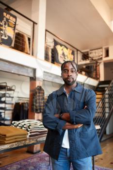 Portrait Of Male Owner Of Fashion Store Standing In Front Of Clothing Display