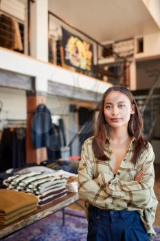 Portrait Of Female Owner Of Fashion Store Standing In Front Of Clothing Display