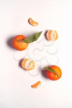 Overhead View Of Whole And Peeled Fresh Satsuma With Leaves On White Background