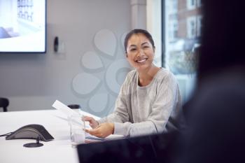 Smiling Asian Businesswoman Sitting At Table In Office  Meeting Room