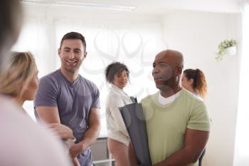 People In Exercise Clothing Meeting And Chatting Before Fitness Or Yoga Class In Community Center
