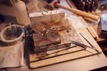 Close Up Of Jewellers Workbench With Tools And Designs  In Studio