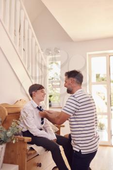 Father Helping Son To Tie Necktie Before He Leaves Home For First Day At High School