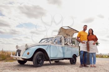 Portrait Of Couple Running Independent Mobile Coffee Shop Standing Outdoors Next To Van