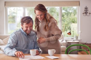 Couple With Pregnant Wife Reviewing Domestic Finances Together