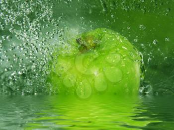 Water splashing onto a green apple