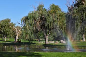Decorative fountain and shining rainbow on the golf course