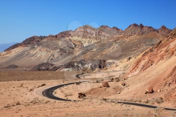 Winding road in Death Valley. Dry clay soil and a cloudless sky