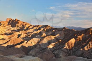 The famous section of Death Valley in California - Zabriskie Point. Picturesque hills of pink, yellow and chocolate hues. Sunset
