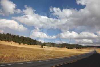 Road to the Grand Canyon. Autumn yellow fields and the magnificent cloudy sky
