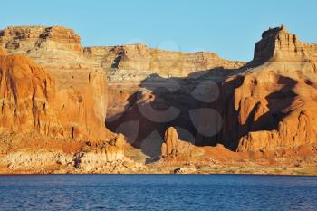 Magnificent red sandstone cliffs on the shores of Lake Powell. Arizona, United States, sunset
