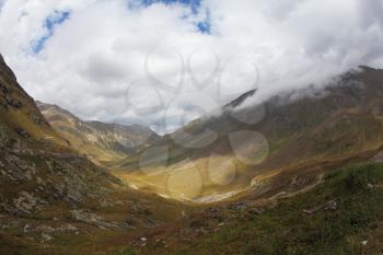 Wonderful valley in the mountains of northern Italy in the sunlight on a cloudy autumn day
