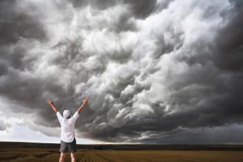 The enthusiastic tourist welcomes thunderstorm above Montana. Fields after a harvest