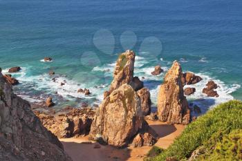 Picturesque rocks on a secluded beach Atlantic Ocean. Coast of Portugal, Cabo da Roca - the westernmost point of Europe. Morning sunrise