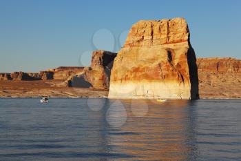 Magnificent Lake Powell at sunset. Tourist boats and cliffs reflected in the lake