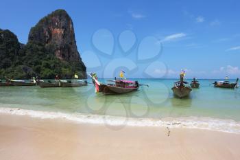 Magic beach on island. Picturesque native boats Longtail expect the first morning tourists
