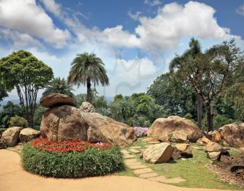 The beautiful park in Southeast Asia in Thailand. Gorgeous flower beds, lawns and tropical trees