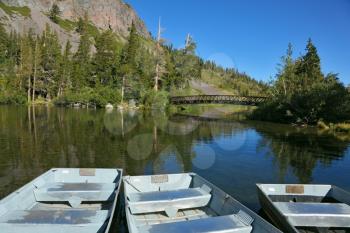 Small boats made of white metal on a quiet mountain lake