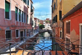 The easy wooden bridge through the Venetian channel. Small street to Venice, a sunny day