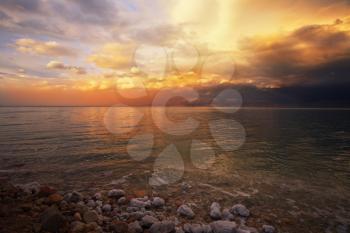 Coast of the Dead Sea in Israel in a spring thunder-storm. The coastal stones covered by salty adjournment