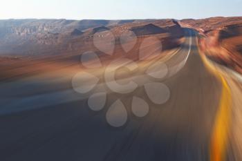 Trip driving on high speed on highway in stone desert. A sunset