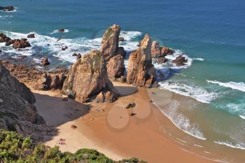 Picturesque rocks on a lonely beach of Atlantic ocean. Coast of Portugal, cape Cabo da Roca  - the most western point of Europe. Morning, sunrise