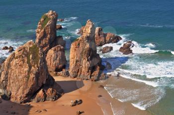 Picturesque rocks on a lonely beach of Atlantic ocean. Coast of Portugal, cape Cabo da Roca  - the most western point of Europe. Morning, sunrise
