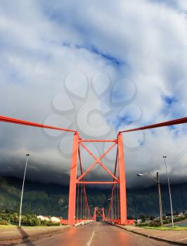Red bridge over the fjord. Recently, there was a thunderstorm. Patagonia, Chile. The picture was taken Fisheye lens