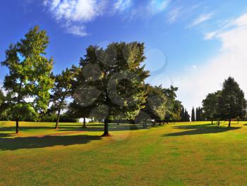 The most romantic landscape park garden in Italy. Lovely green grassy lawn at sunset